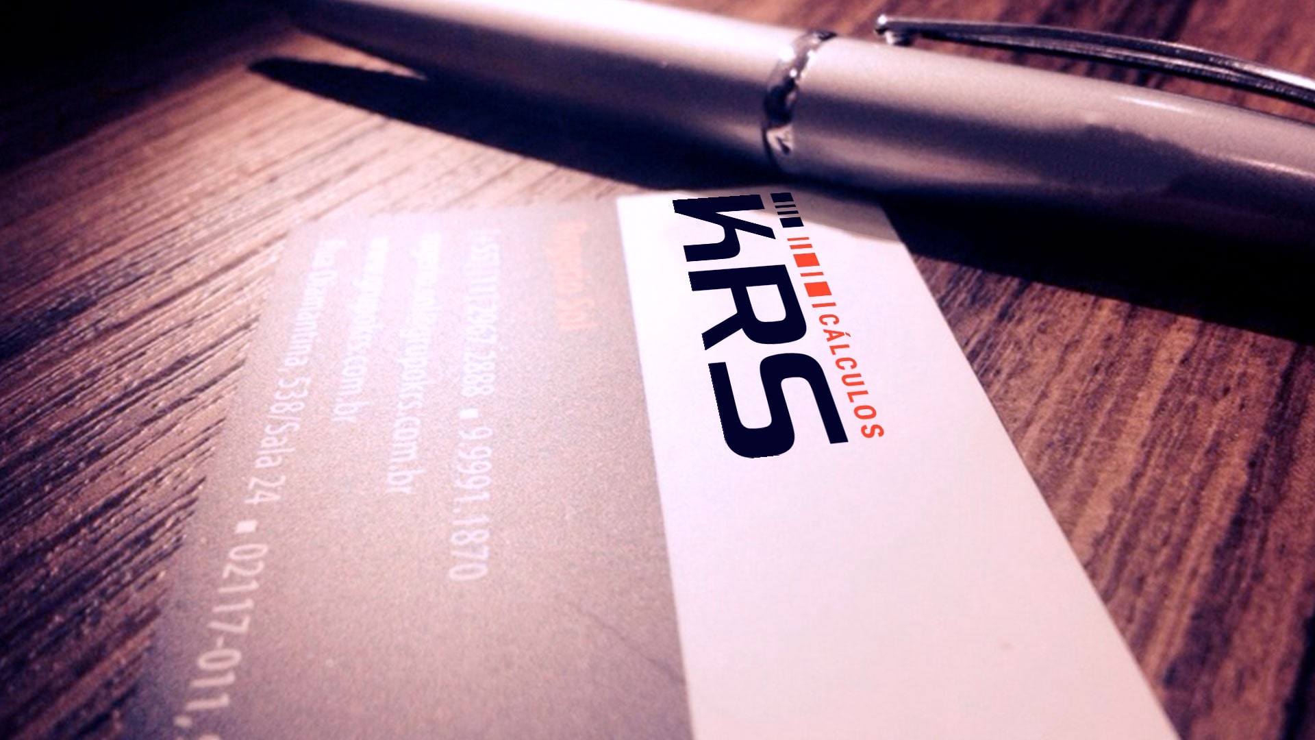 Cartão de visita e uma caneta com logo da KRS